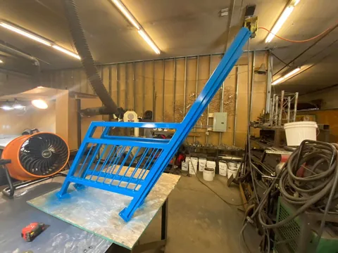 Blue finished custom steel frame in the fabrication shop