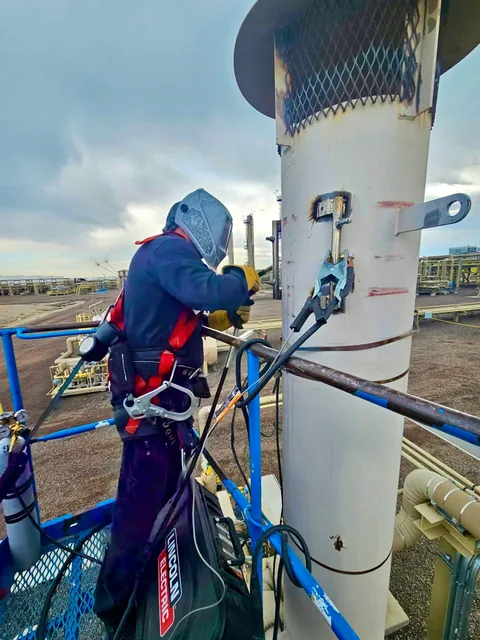 Welder working from an elevated platform on a steel structure