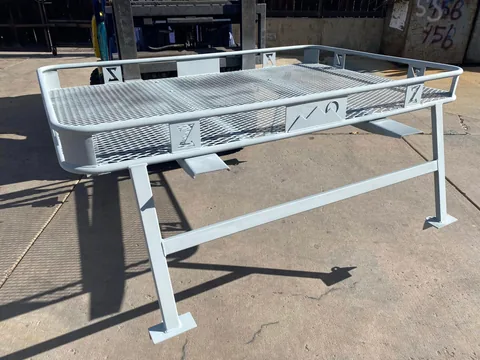 Large fabricated steel mesh platform on shop stands